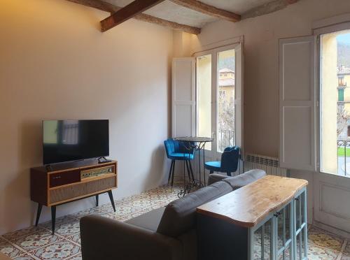 sala de estar con sofá y TV en Casa Clotilde - Apartamento elegante y cómodo en Sant Joan de les Abadesses, en Sant Joan de les Abadesses