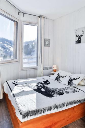 une chambre avec un lit avec une grande fenêtre dans l'établissement IMMODREAMS - Le Pas du Lac - Avoriaz, à Avoriaz