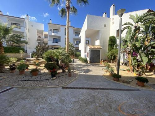 un edificio con palmeras y plantas en un patio en Beautiful Apartment Alfaz del Sol en L’Alfàs del Pi