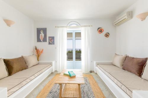 a white living room with two couches and a table at Glyfa Village in Drios