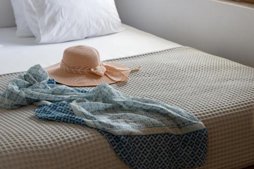 einen Hut und eine Decke auf dem Bett in der Unterkunft Basilico Suites Adults Only in Gouves
