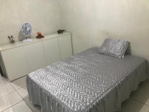 Schlafzimmer mit einem Bett mit einem Kissen und einem Ventilator in der Unterkunft Casa de Temporada no Maior São João do Mundo in Campina Grande