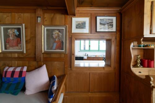 um quarto com paredes de madeira, uma janela e pinturas em Chammern em Nesslau