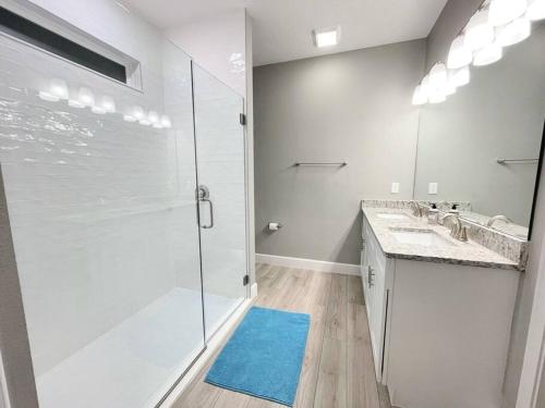 a white bathroom with two sinks and a shower at The Sanford Bandstand in Sanford
