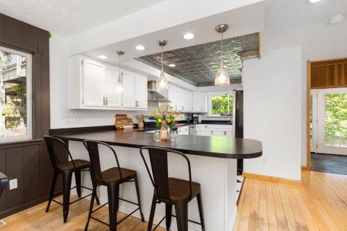 a kitchen with a large black island with chairs at Vineyard Haven AC Jacuzzi Sauna Private En Suite in Traverse City