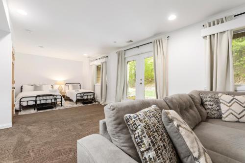 a living room with a couch and a bedroom at Vineyard Haven AC Jacuzzi Sauna Private En Suite in Traverse City