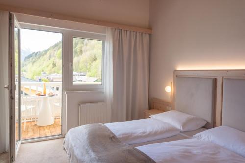 a hotel room with two beds and a window at das zellersee in Zell am See