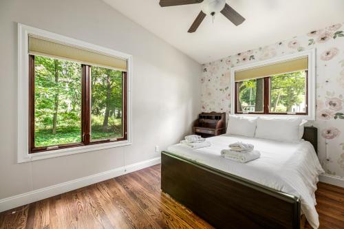 a bedroom with a bed and two windows at The Milliken Getaway AC Beach Fire Pit BBQ in Traverse City