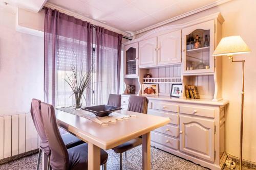 a dining room table with chairs and a laptop on it at Precioso apartamento con terraza en Valencia in Valencia