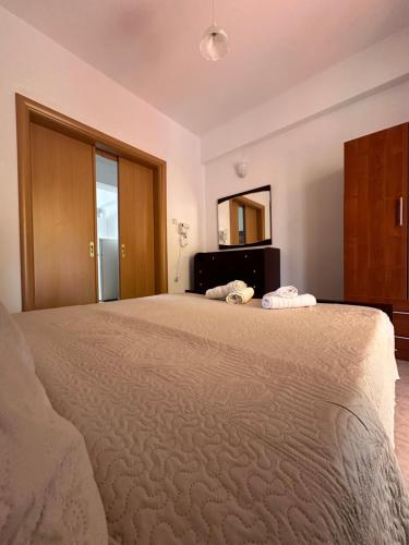 a bedroom with a large bed and a mirror at Dimos apartments in Kokkino Nero