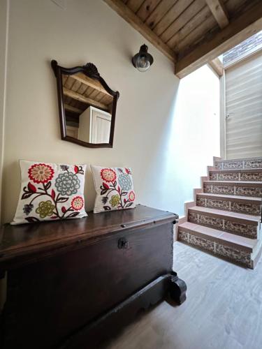 a room with a bench with a mirror and stairs at Casa Rural Casa Isabel in Hervás