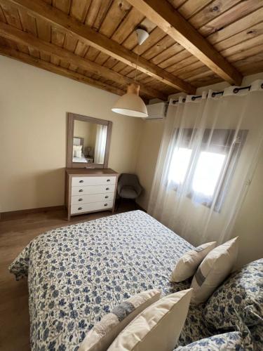 1 dormitorio con cama, tocador y espejo en Casa Rural Casa Isabel, en Hervás