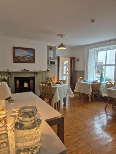 - un salon avec des tables, des chaises et une cheminée dans l'établissement The Old Exchange, à Clifden