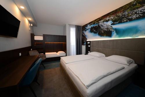 クランスカ・ゴーラにあるホテル アルピナのベッドルーム1室(壁に絵画が描かれたベッド1台付)