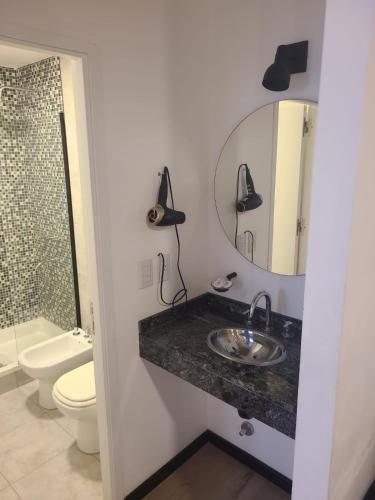a bathroom with a sink and a toilet and a mirror at Departamento - Salta Capital - Edificio Usina in Salta