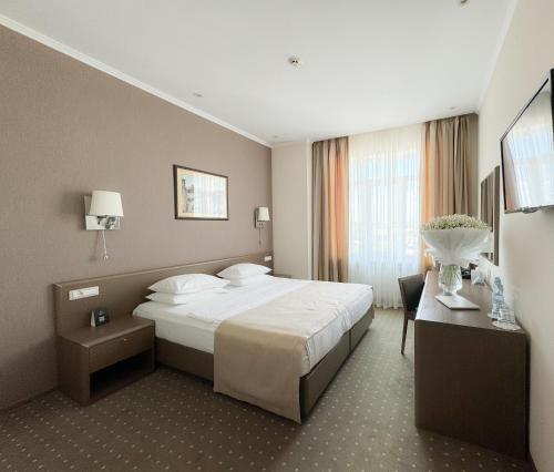 オデッサにあるアレクサンドロフスキー ホテルのベッドとデスクが備わるホテルルームです。