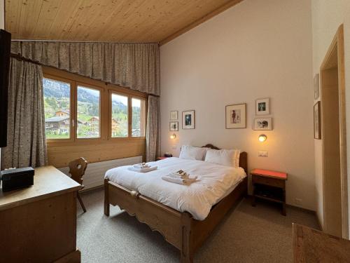 a bedroom with a large bed and a window at Chalet Bella Vista 12 - Penthouse in Wengen