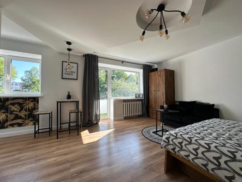 - une chambre avec un lit et un salon dans l'établissement Hugo apartment, à Šiauliai