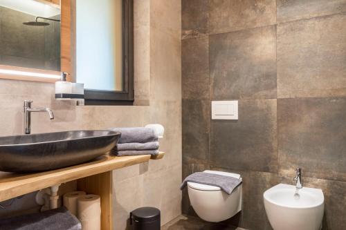 a bathroom with a black sink and a toilet at Blosegghof Bergchalets Himmelblick in Racines