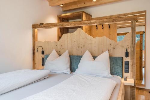 a bedroom with two beds with white pillows at Blosegghof Bergchalets Himmelblick in Racines