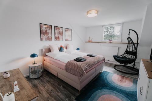 a bedroom with a bed and a chair in it at großzügiges, stylisches Apartment I 6 Personen I Eifel I Naturliebhaber I in Metterich