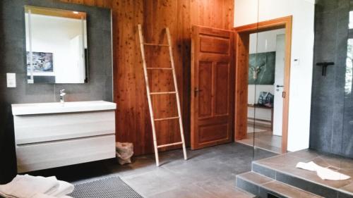 a bathroom with a sink and a ladder next to a mirror at FeWo "Bergstift" Oberstaufen/Höfen in Oberstaufen
