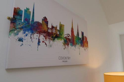 a painting of a city on a wall at 2 Bedroom Penthouse in Coventry - Private Parking in Coventry