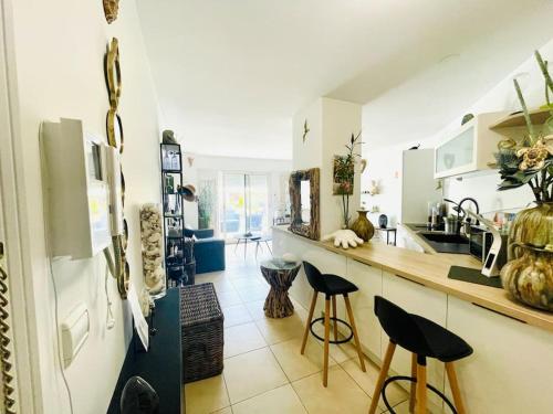 - une cuisine avec un comptoir et des tabourets dans l'établissement Le Victoria Beach, beau T2 à 1 minute des plages, à Menton