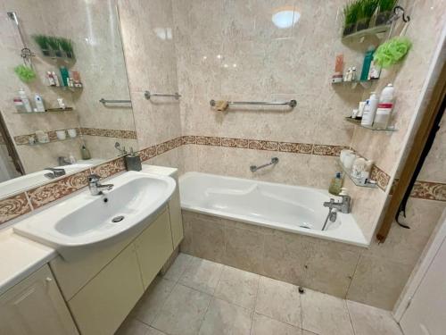 une salle de bain avec une baignoire et un lavabo et une baignoire dans l'établissement Le Victoria Beach, beau T2 à 1 minute des plages, à Menton