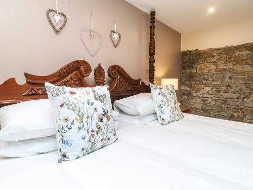 a bedroom with a bed with white sheets and pillows at The Croft in Holsworthy