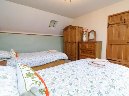 a bedroom with two twin beds and a dresser at The Croft in Holsworthy