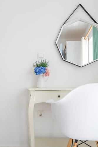 a white desk with a mirror on a white wall at Glyfa Village in Drios