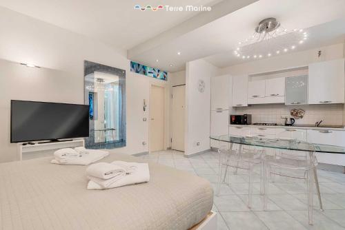 Duży, biały pokój ze szklanym stołem i kuchnią w obiekcie Élite, Terre Marine w mieście La Spezia