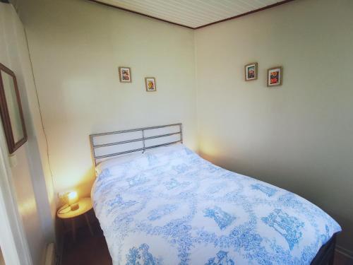 een slaapkamer met een bed met een blauw en wit dekbed bij Printemps Quatre Saisons in Bergerac