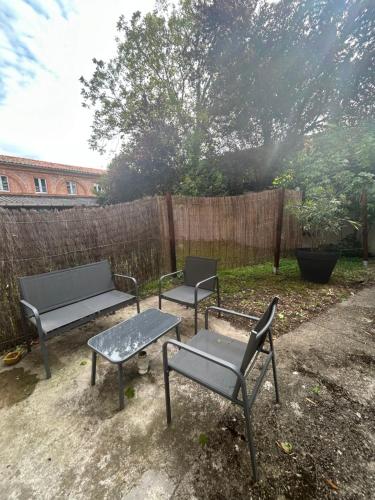 drie stoelen en een bank in de achtertuin bij Le cosy Balat Biel RDC jardin spacieux in Grisolles