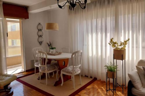 a dining room with a white table and chairs at Solerma in Viveiro