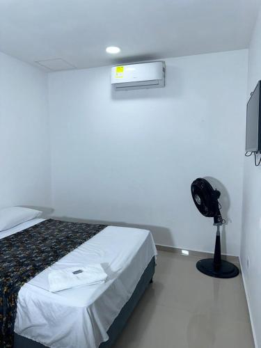 a bedroom with a bed and a fan and a television at lujoso apartamento central con tres Aires acondicionados y parqueo in Montería
