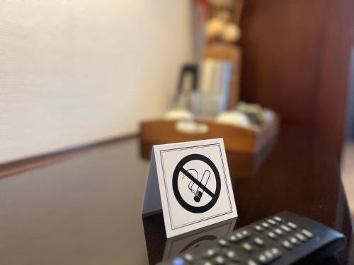 a no smoking sign on a table next to a remote control at Central Hotel in Worms