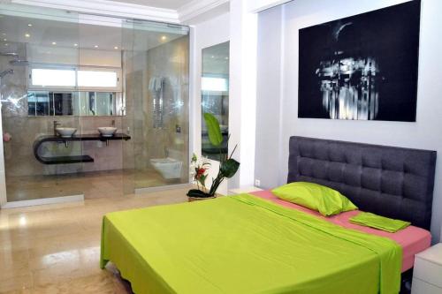 1 Schlafzimmer mit einem grünen Bett und einem Badezimmer in der Unterkunft Superbe appartement a La Marsa in La Marsa
