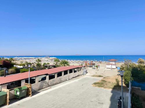 - un bâtiment sur une plage avec l'océan en arrière-plan dans l'établissement 13 Sandy Beach Mackenzie, à Larnaka