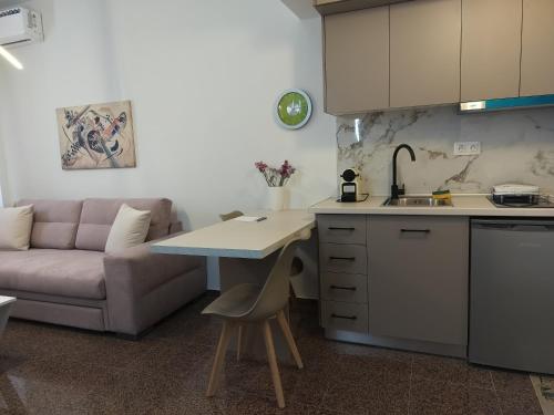 a kitchen with a couch and a table in a kitchen at Nefeli -1BR Lux Apartment - Tsimiski Ladadika - Explore Center by foot - Close to Aristotelous square in Thessaloniki