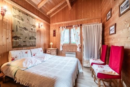 een slaapkamer met een bed en twee rode stoelen bij Chalet esprit Savoyard in Vacheresse