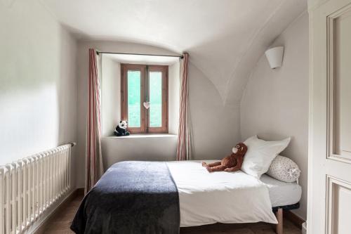a teddy bear sitting on a bed in a bedroom at Bed end breakfast du centre in Bourg-Saint-Maurice