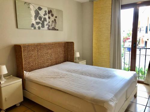 uma cama num quarto com uma grande janela em Alfaz del Sol Piscina y Relax em L'Alfàs del Pi
