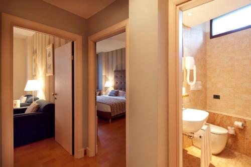 uma casa de banho com WC e um quarto com cama em Hotel dei Duchi em Spoleto