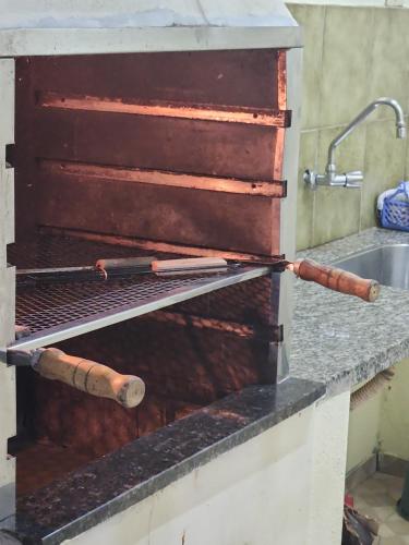encimera de cocina con 2 utensilios de cocina de madera en Condomínio Lesther, en Ubatuba