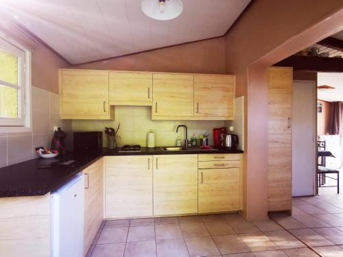 een keuken met houten kasten en een wastafel bij Printemps Quatre Saisons in Bergerac