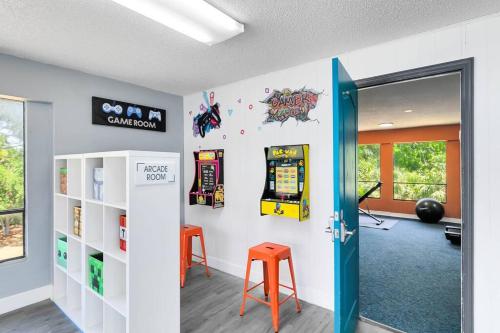 a room with two orange stools and a video game at Oasis 203 - Symmetry & Serenity in Titusville