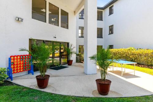 a building with two potted plants in front of it at Oasis 203 - Symmetry & Serenity in Titusville