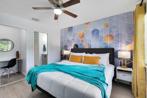 a bedroom with a large bed with a blue blanket at Oasis 203 - Symmetry & Serenity in Titusville